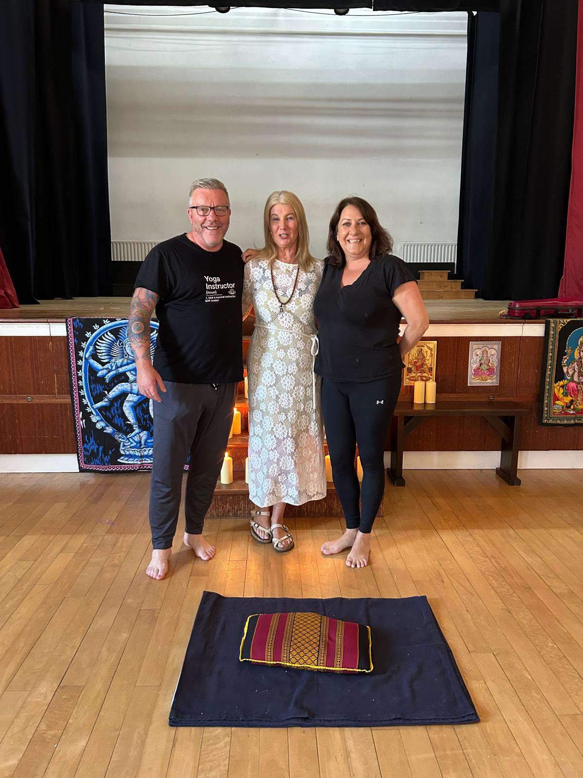 A graduate photographed with Michael Connolly and Mary Dowling beside the candlelit altar