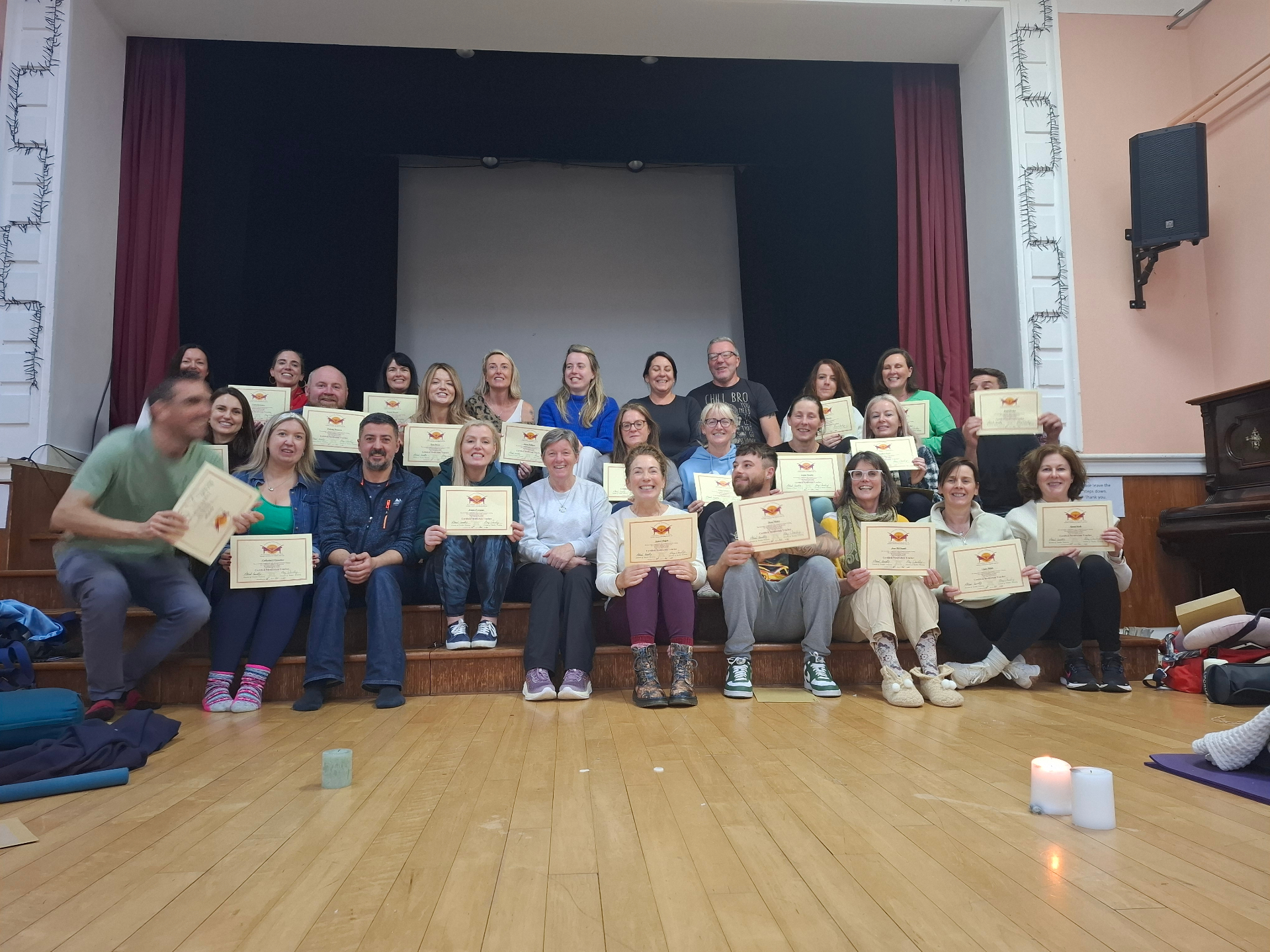 AlphaZone graduating class holding their certificates in the training hall